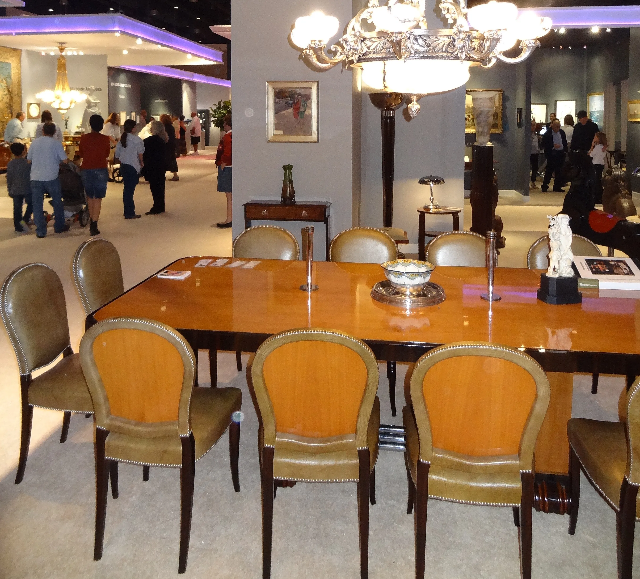 Mesa de comedor antigua, capacidad para 10 a 12 personas. Decorada con sillas elegantes en un ambiente acogedor.